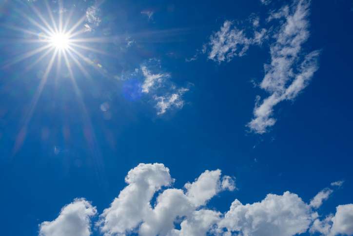 Midsummer sun and blue skies, pouring down ultraviolet rays, intense sunlight.