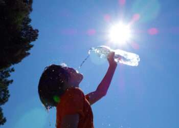 Child pouring water on himself.